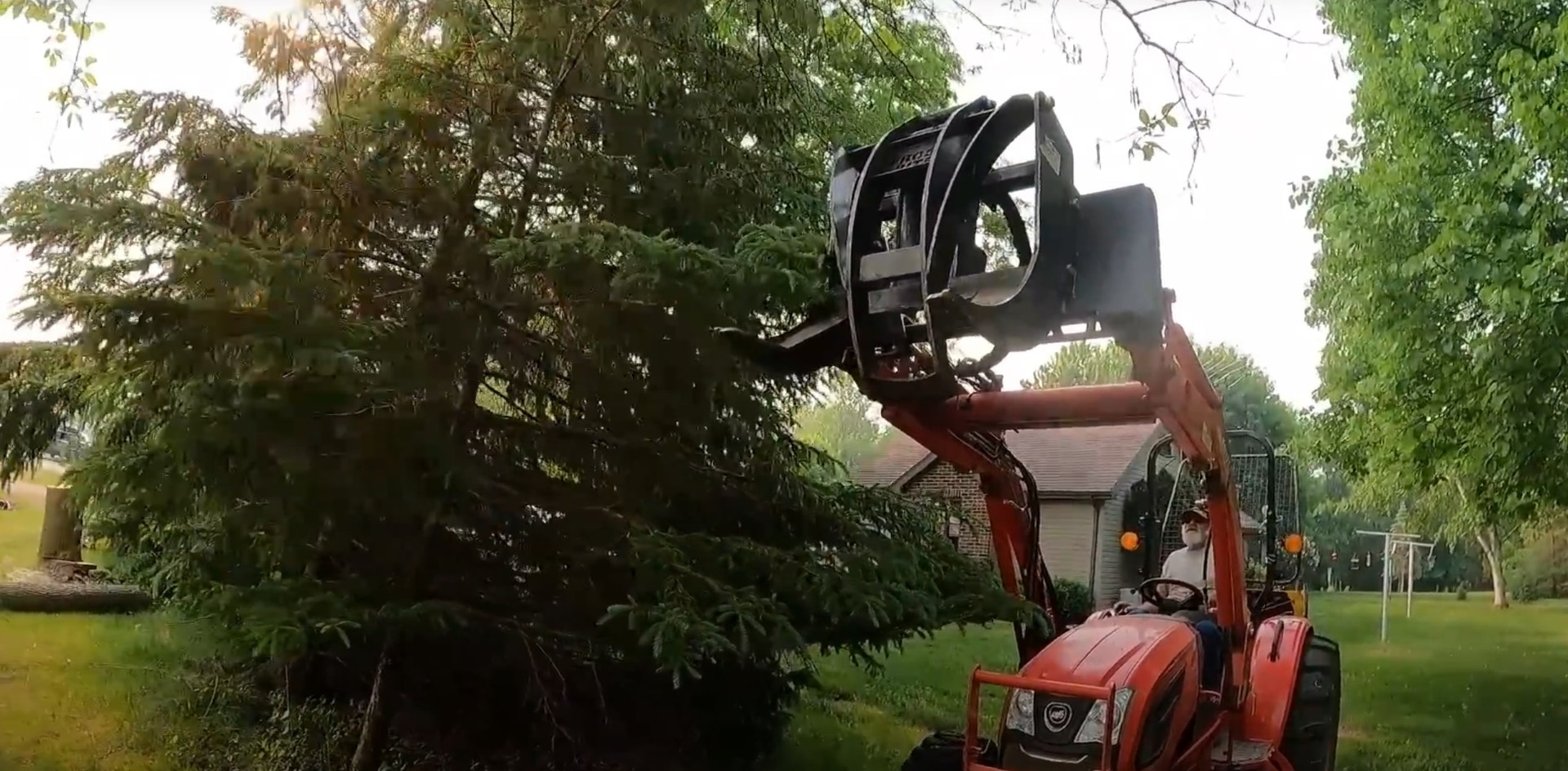 Professional tree removal equipment in action Heavy equipment performing tree removal in residential yard